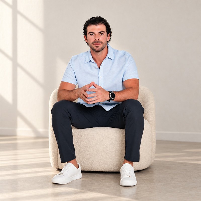 Victor Ruiz, broker inmobiliario en Cancún, sentado en un sillón con luz natural de ventana al fondo